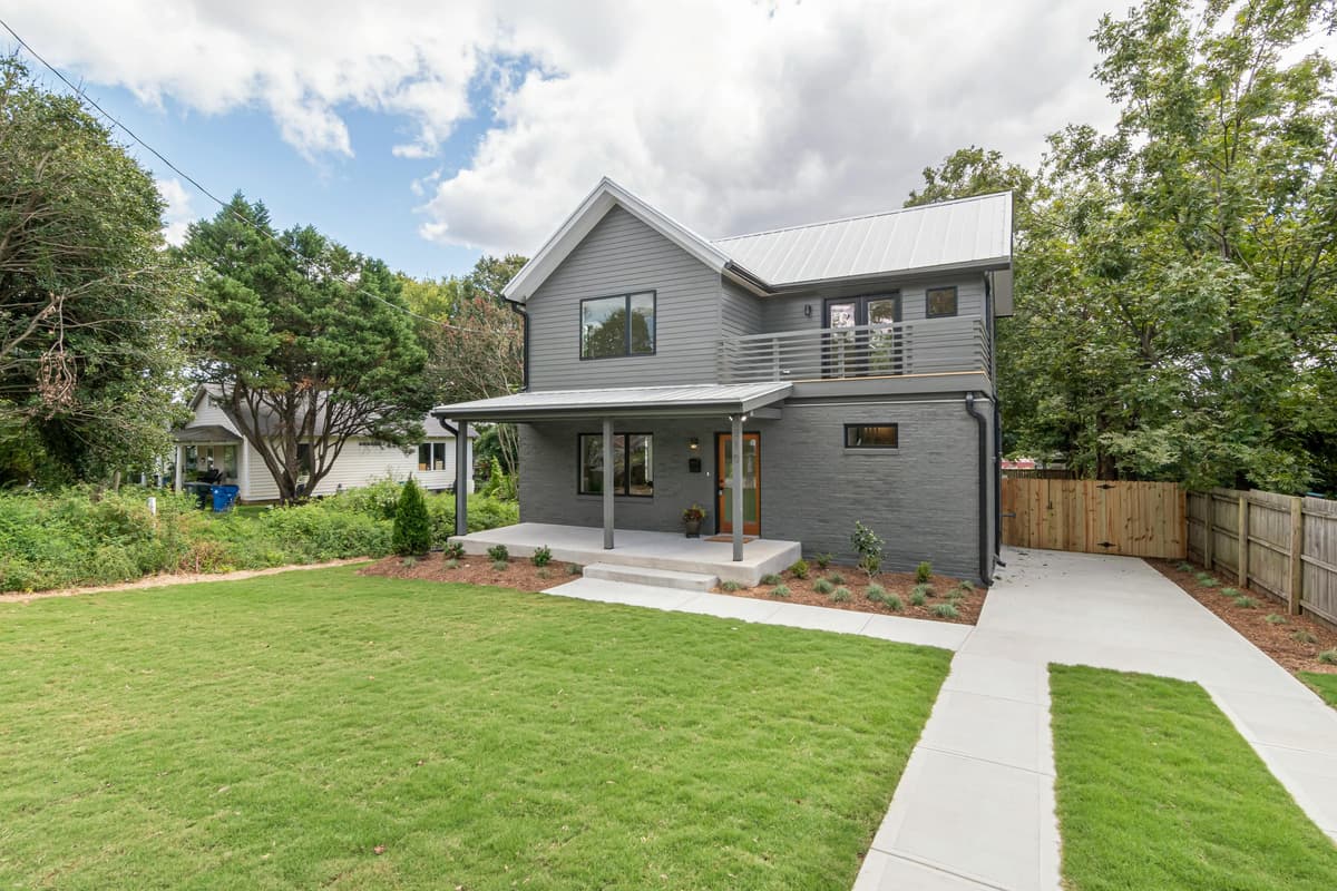 Modern home with a manicured green front lawn and freshly mulched beds